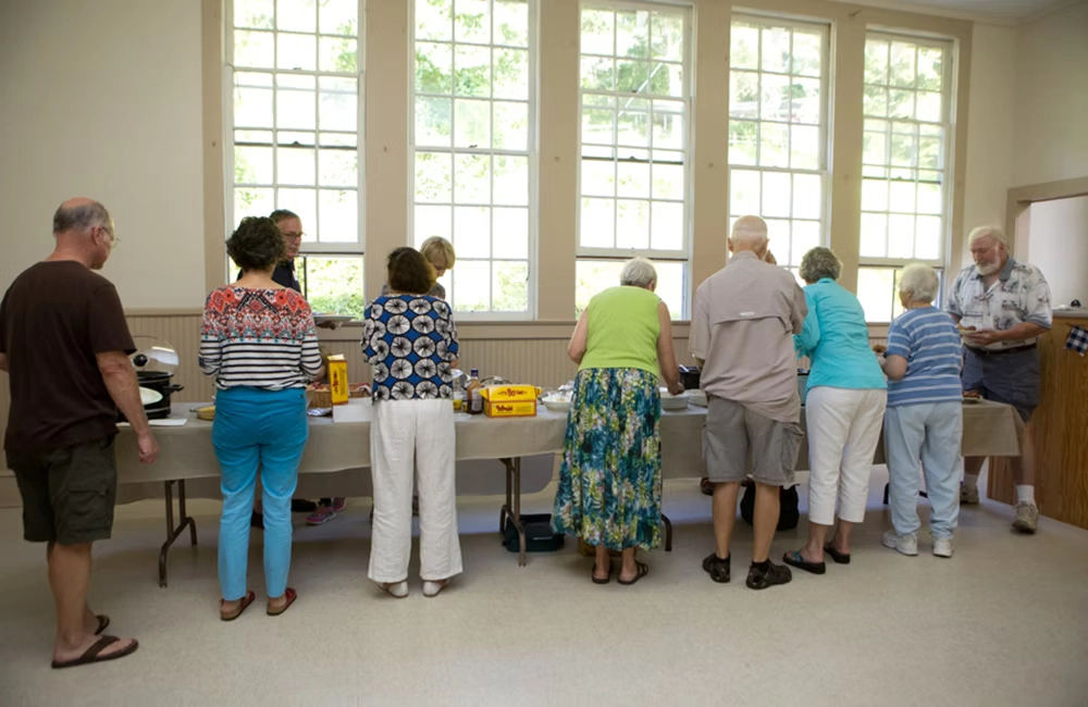 Residents getting food at the Balsam Community Center Potluck dinner